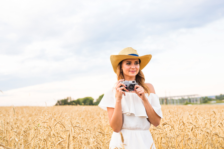 female photographer in the field with a camera taking picturesの写真素材