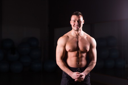 Young handsome muscular man bodybuilder posing