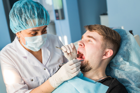 Dentist doing a dental treatment on a patientの写真素材
