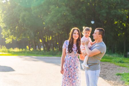 parents with baby daughter in parkの写真素材