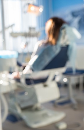 blur image of woman sitting in the dentists office for background usage.の写真素材