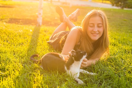 young happy smiling woman with cat on natural backgroundの写真素材