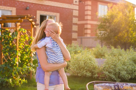 Playful woman in the garden playing with her baby sonの写真素材