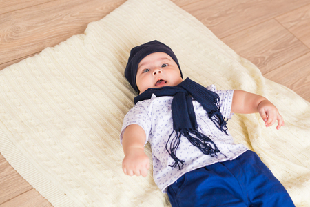 Portrait of a little adorable newborn infant baby boy lying on back on blanketの写真素材