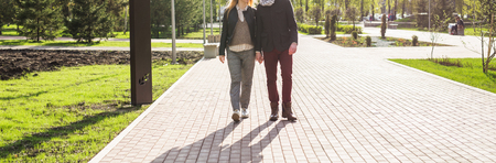Stylish couple in love holding hands on the street, woman is pregnantの写真素材