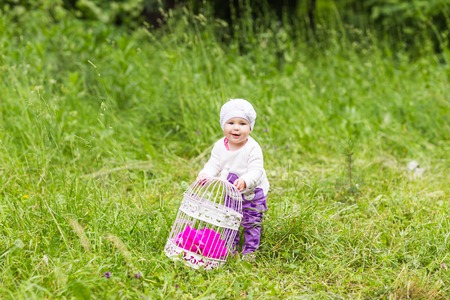 baby girl playing on the green grassの写真素材