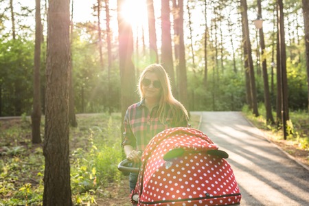 Mother walking with a stroller in the park.の写真素材
