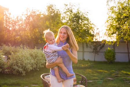 Playful woman in park playing with her laughing son