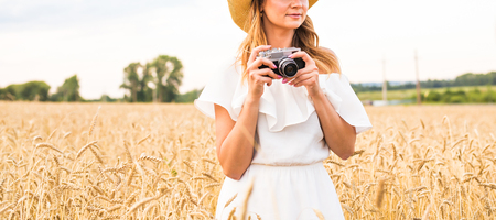 Pretty girl with vintage camera outdoors, close-upの写真素材