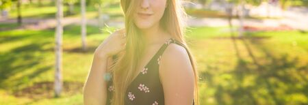 Attractive young woman enjoying her time outside in park with sunset in background.の写真素材