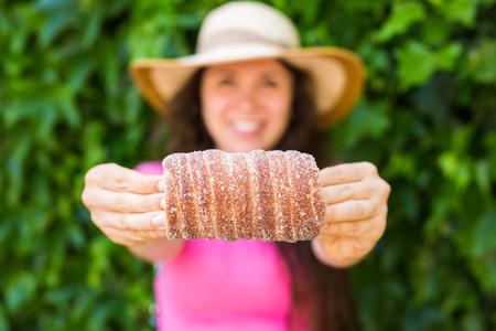 Close-up of young female tourist with traditional czech dessert trdelnik in Prague. Czech Republic. Outdoorの写真素材