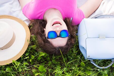 Top portrait of young woman laying on the grass in the parkの写真素材