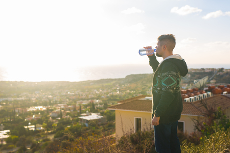 Portrait of a man drinking water from a bottle outsideの写真素材