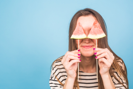 Summer, vacation, diet and vegans concept - Beautiful smiling young woman holding watermelon slice on stickの写真素材