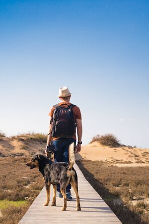 Outdoors lifestyle image of travelling man with cute dog. Tourism concept.の写真素材