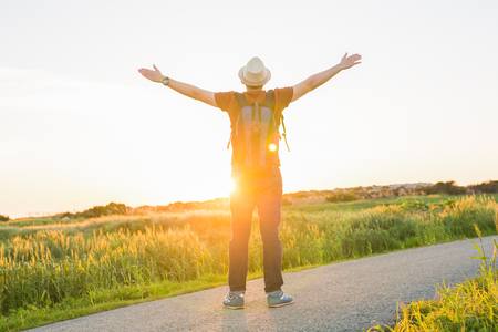 Man with arms raised, looking out over field.の写真素材