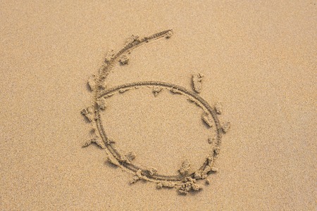 Six number written on sand on summer beachの写真素材
