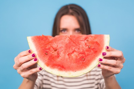Summer, vacation, diet and vegans concept - Beautiful smiling young woman holding watermelonの写真素材