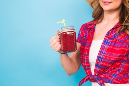 Woman holding a cup of fruit smoothieの写真素材