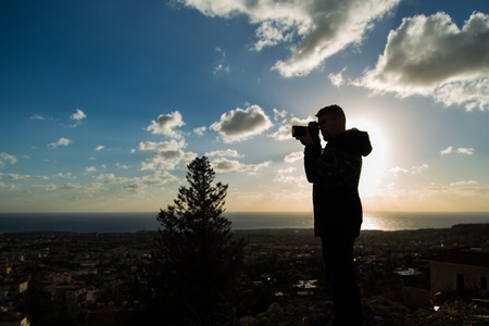 Travel, vacation, photographer and hitchhiker concept - Silhouette of traveler man photographed...
