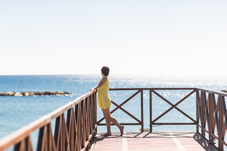 Beautiful woman in summer outfit posing . Holiday vacation mood. Bright blue dress.の写真素材