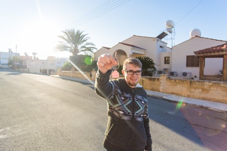 Property, ownership, new home and people concept. Cheerful young man holding house key.の写真素材