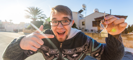 Property, ownership, new home and people concept - Young funny man moving into new homeの写真素材