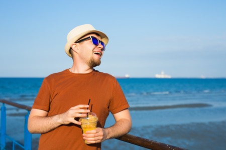 Handsome hipster man with paper coffee cup on streetの写真素材
