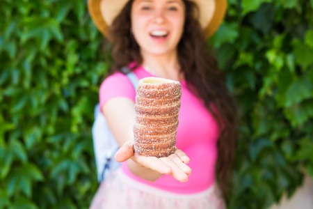 Close-up of young female tourist with traditional czech dessert trdelnik in Prague. Czech Republic. Outdoor.の写真素材