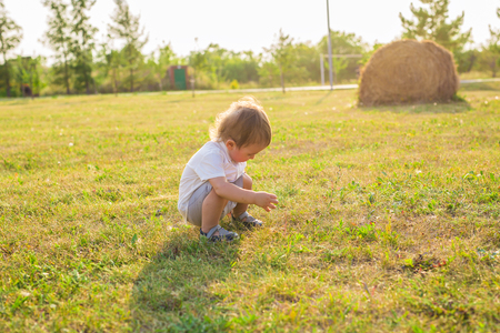 Happy laughing baby boy playing on summer or autumn field.の写真素材