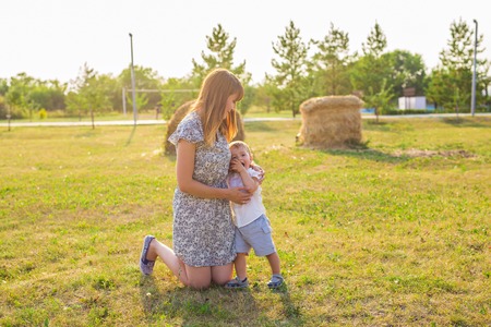 Cute cheerful child with mother play outdoors in parkの写真素材