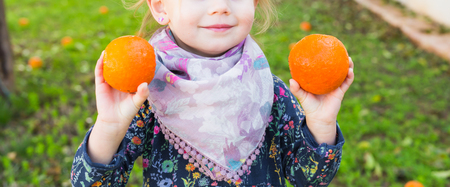 Happy laughing child playing with orange close upの写真素材