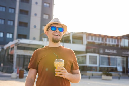 handsome bearded man with paper cup of morning coffee walking in morning.の写真素材