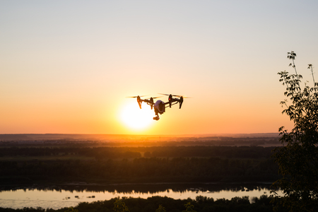 quadrocopter drone with remote control. Dark silhouette against colorfull sunset.の写真素材