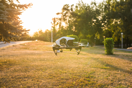 Ufa, Russia. - August 8, 2016: White drone, quadrocopter with photo camera flying in the blue sky.のeditorial素材