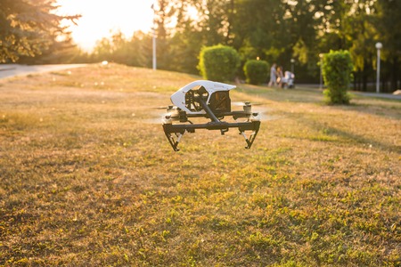 Ufa, Russia. - August 8, 2016: White drone, quadrocopter with photo camera flying in the blue sky.のeditorial素材