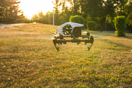 Ufa, Russia. - August 8, 2016: White drone, quadrocopter with photo camera flying in the blue sky.のeditorial素材