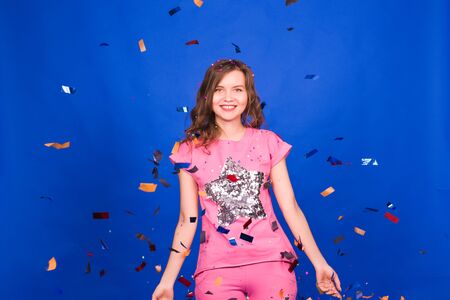 Party time. Cheerful young happy woman or teen girl with confetti