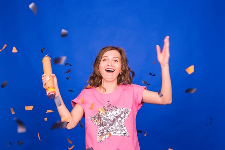 Beautiful happy woman at celebration party with confetti falling everywhere on her. Birthday or New Year eve celebrating conceptの写真素材