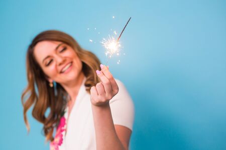 Woman Sparkler Celebration Happiness Firework Concept on blue backgroundの写真素材