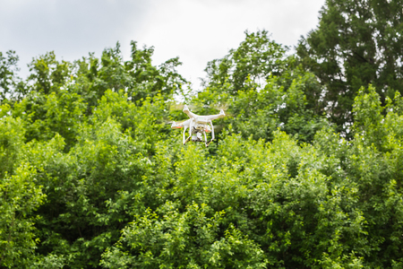 White drone, quadrocopter with photo camera flying in the blue skyのeditorial素材