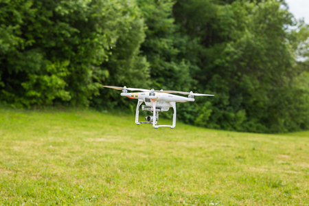 White drone, quadrocopter with photo camera flying in the blue skyのeditorial素材