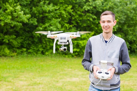 White drone, quadrocopter with photo camera flying in the blue sky