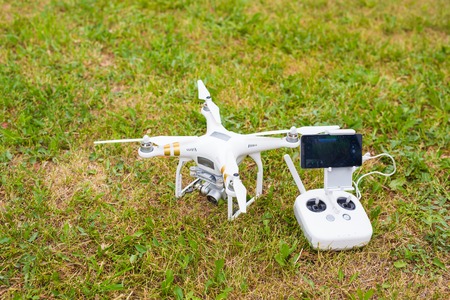White drone, quadrocopter with photo camera flying in the blue sky