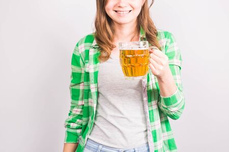 Young woman holding fresh beer in studioの写真素材