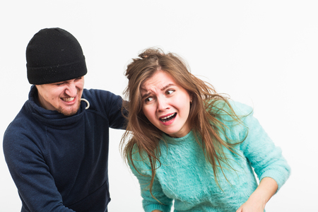 Woman victim of violence and abuse. Criminal man beats a woman on white backgroundの写真素材