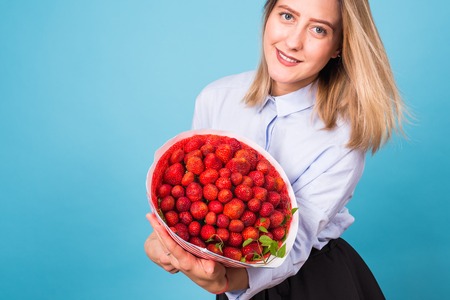 Close up of beautiful woman holding bouquet made of strawberryの写真素材