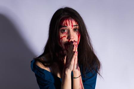 Rape battered bloody victim sad woman sits on the floor of a dark tunnel. Sexual assault concept...
