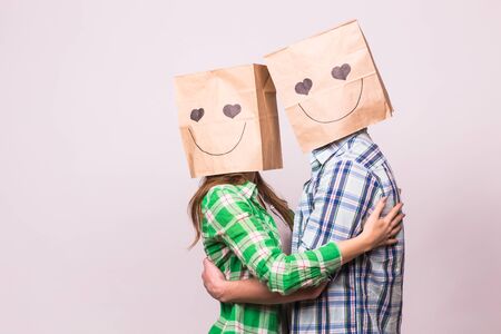 Valentines day concept - Young love couple with bags over heads on white backgroundの写真素材