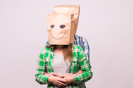 Valentine's day concept - Young love couple with bags over heads on white background.の写真素材